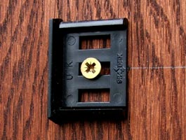 Close up view of door sign clip screwed to wooden door